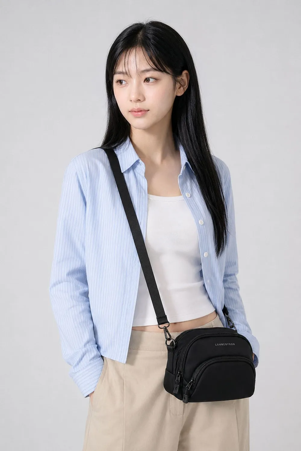 타코백 플러스, 연한 파란 셔츠 차림 여성이 검은 가방을 대각선으로 멘 상반신