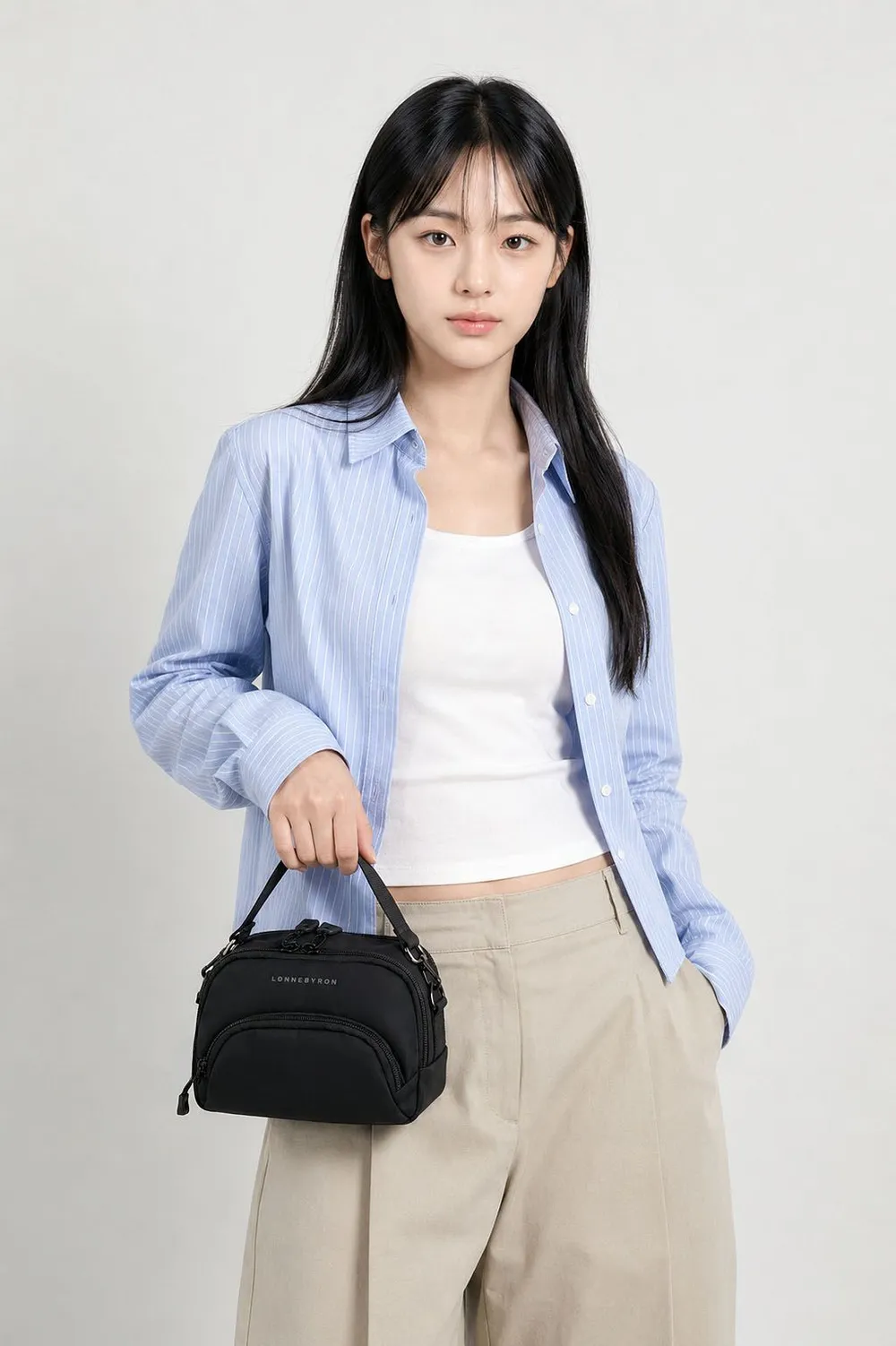 타코백 플러스, 파란 셔츠 차림 여성이 검은 가방을 한 손에 든 전신